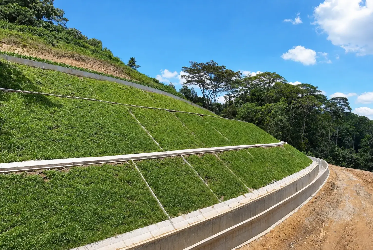 Completed turfed slope and landscaped verge alongside a finished road
